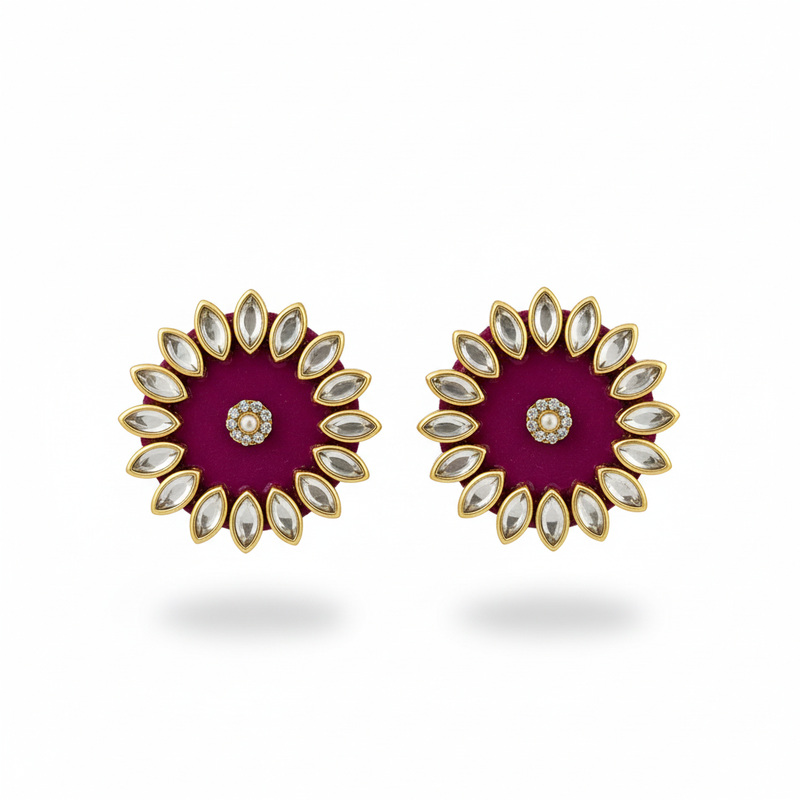 Pair of earrings with a purple center and gold and white accents on a white background