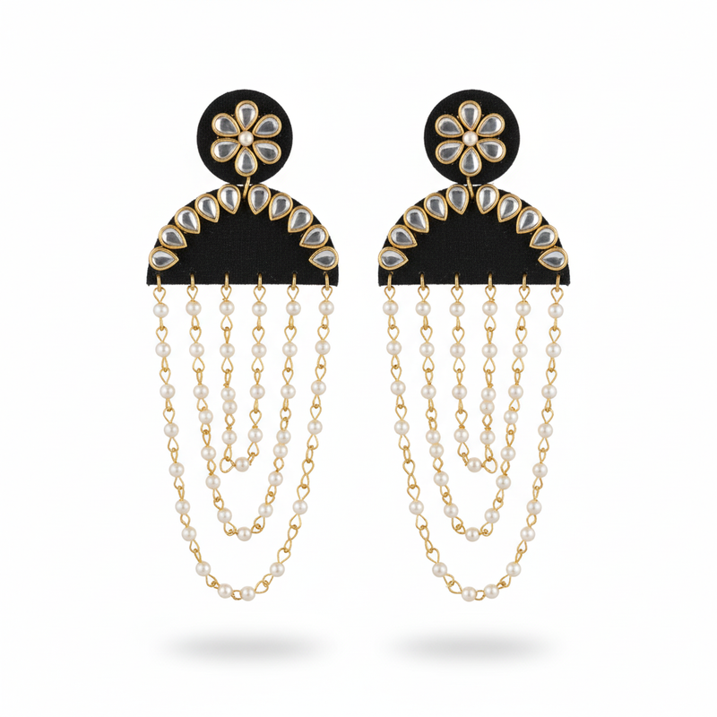 Pair of earrings with black floral tops and gold chains on a white background